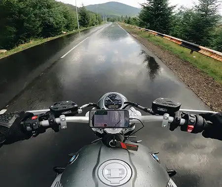 Motorrad fährt auf nasser Fahrbahn